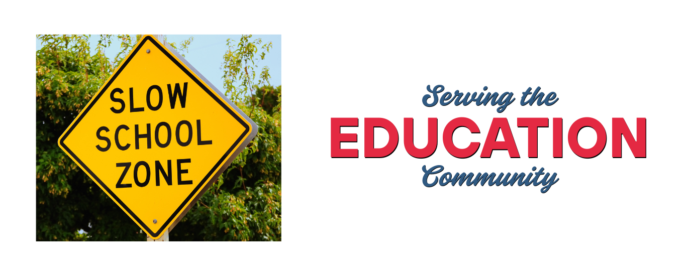 Yellow school zone sign with 'Serving the Education Community' message, promoting school signage solutions